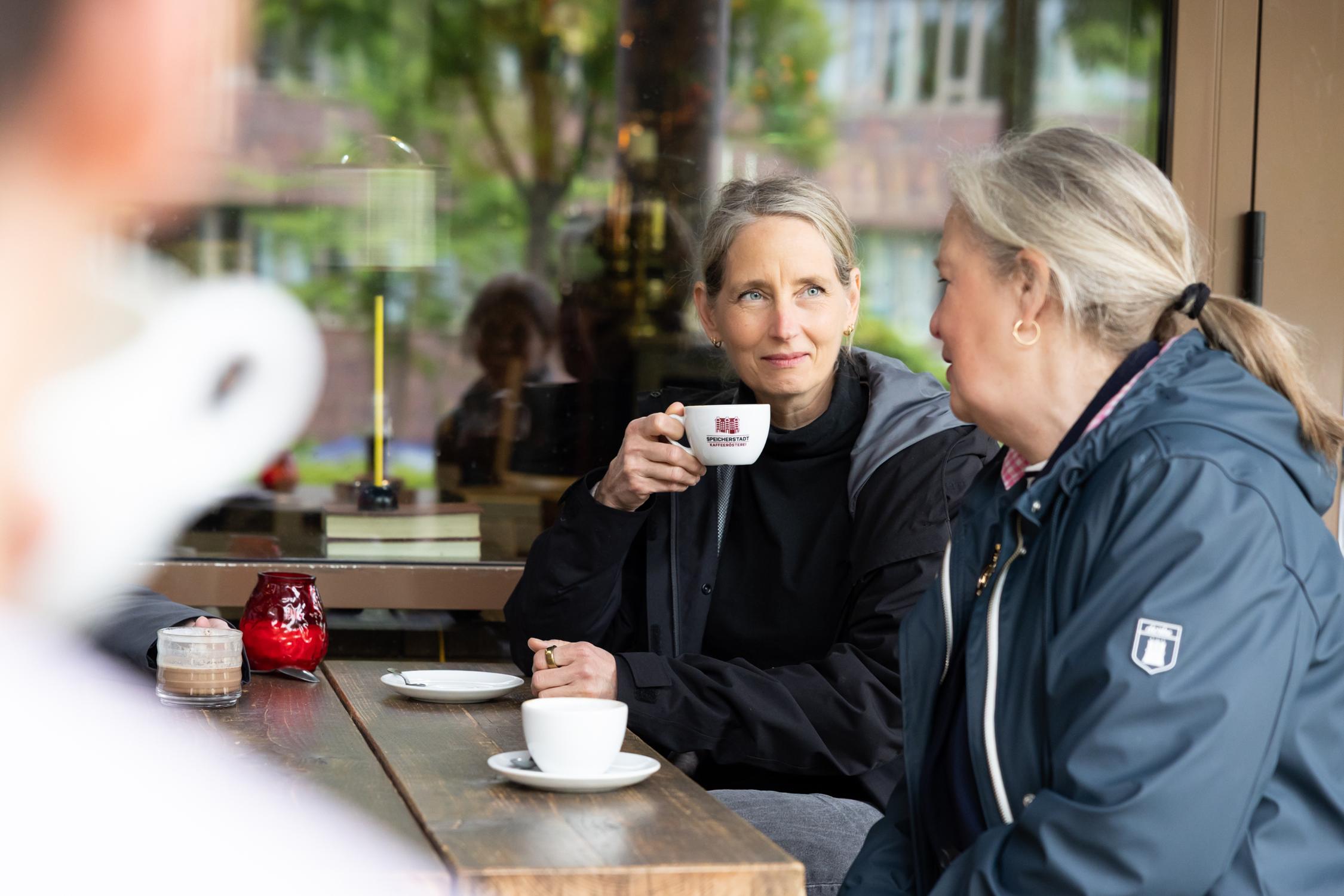 Ehrenamtliche trinken Kaffee und unterhalten sich.
